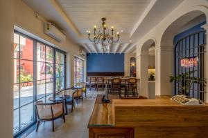 帕纳吉O Pierre的餐厅设有酒吧,配有桌椅和窗户