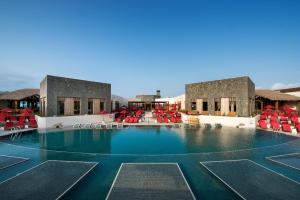 拉哈雷斯Pierre & Vacances Resort Fuerteventura OrigoMare的度假村内带红色椅子的大型游泳池