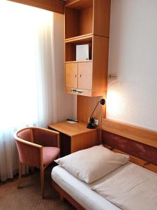 大恩策斯多夫穆勒尔高德纳旅馆的一间卧室配有一张床、一张桌子和一把椅子