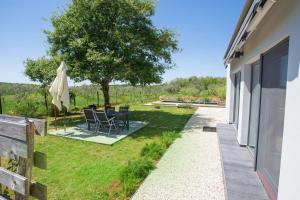 罗波里卡Cottage House Loborika with Pool的花园配有桌椅和一棵树