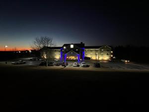 FairfieldBudgetel Inns & Suites的夜间停车场内紫色灯的建筑