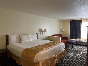 FairfieldBudgetel Inns & Suites的配有一张床和一把椅子的酒店客房