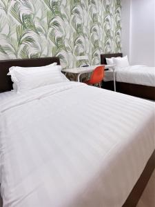 瓜拉丁加奴Hotel Decentraland Kuala Terengganu的卧室配有白色的床和壁纸