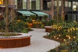 伦敦Luxury Apartments in a vibrant part of North London的一座带灯光和树木的花园以及一座建筑