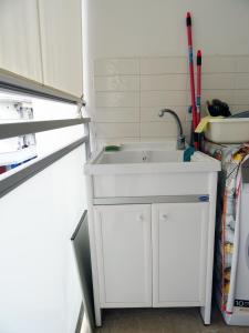 佩斯卡拉appartamento fronte mare的冰箱旁厨房的白色水槽
