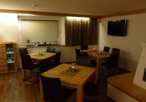 滨湖采尔姆赫勒膳食公寓酒店的一间在房间内配有桌椅的餐厅