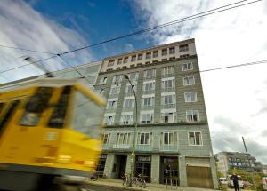 柏林柏林米特简那瑞特酒店的一辆黄色的公共汽车驶过高高的建筑