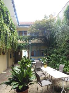 波城珀思提隆酒店的户外庭院设有桌椅和植物