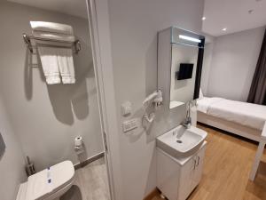 伊斯坦布尔10m2 Hotel的一间带卫生间、水槽和镜子的浴室