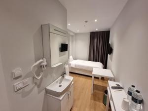 伊斯坦布尔10m2 Hotel的白色的浴室设有水槽和一张床