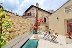 圣塞韦里诺马尔凯Guest House Viaroma的砖墙旁的庭院,设有游泳池
