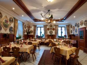 格拉绍Hotel-Gasthof Sperrer的一间带桌椅和吊灯的餐厅