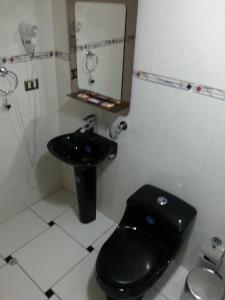 利马帕达玛酒店的浴室设有黑色的卫生间和水槽。