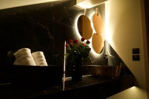 米卢斯Magnifique Villa le89golden jacuzzi et sauna privatif的浴室设有水槽、镜子和花瓶