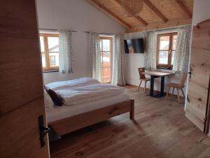 巴特海尔布伦Landhaus Hutter的卧室配有一张床、一张书桌和窗户。