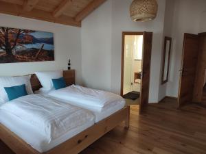 巴特海尔布伦Landhaus Hutter的一间卧室配有带白色床单和蓝色枕头的床。