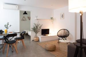 瓦伦西亚Apartamentos FV Flats Valencia - Mestalla 7的客厅配有桌椅和电视。