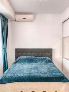 布加勒斯特Calea Crângași的一间卧室配有一张带绿色棉被的床