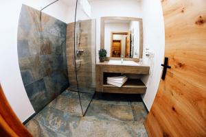 沃拉内特Popasul Domnesc- Resort& Spa- Voronet Vue的一间带水槽和淋浴的浴室