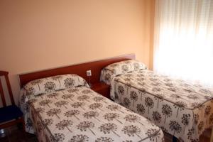 哈拉瓦CASA RURAL HOCES DEL MESA的一间卧室设有两张床和窗户。