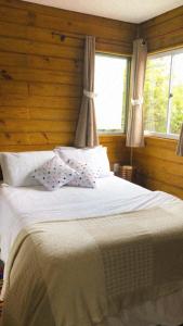 弗洛里亚诺波利斯Bangalôs Floripa - Tiny House的卧室配有一张带两个枕头的大白色床