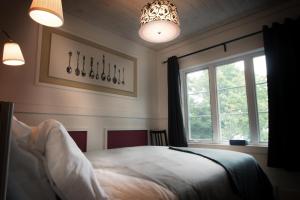 Saint-Raymond七岛港拉克庄园宾馆的一间卧室设有一张床和一个窗口