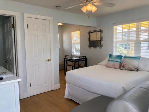 圣徒皮特海滩Sabal Palms Inn的卧室配有白色的床和沙发