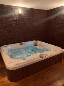 波尔多Mieuxqualhotel jacuzzi privatif Le carré的客房内的按摩浴缸配有蓝色的灯光
