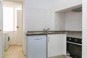 里斯本Estrela Garden Apartment的白色的厨房配有水槽和洗碗机