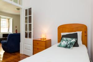 里斯本Estrela Garden Apartment的一间卧室配有一张床和一张蓝色椅子
