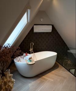 蒙尼肯丹Harbour Suites Boutique Hotel的阁楼设有带浴缸的浴室。