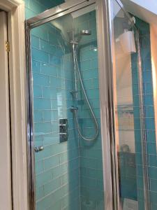 莱姆里吉斯Bentley Rise的蓝色瓷砖浴室设有淋浴和