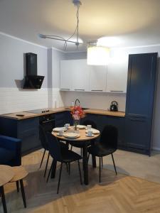 奥普尔Modern Apartment的一间带桌椅的厨房和一间带蓝色橱柜的厨房