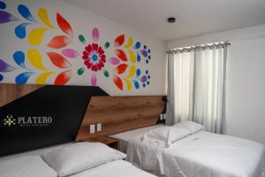阿亚库乔Platero Hotel的一间卧室设有两张床,墙上挂着一幅画
