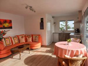 蒂亚斯Apartamento Via Mare的客厅配有橙色沙发和桌子