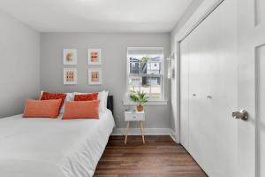 纳什维尔Charming Modern 3-Bedroom Home in East Nashville!的卧室配有带橙色枕头的白色床