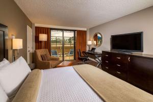 迈阿密Sonesta Miami Airport的配有一张床和一台平面电视的酒店客房