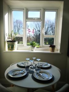 伦敦LUXE HILL GETAWAY的窗前带盘子和餐具的桌子
