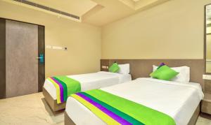 维沙卡帕特南Treebo Trend Sriz Cozy Seethamadhara的一间卧室配有两张带彩虹床单的床