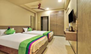 维沙卡帕特南Treebo Trend Sriz Cozy Seethamadhara的酒店客房设有两张床和电视。