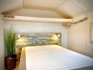 维泽桑讷Dancamps Holmsland的卧室配有一张床铺,位于带墙壁的房间