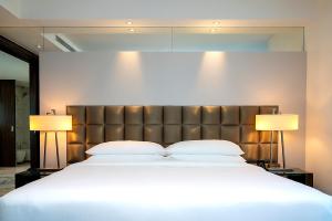 迪拜voco - Bonnington Dubai, an IHG Hotel的一间卧室配有一张大床和两盏灯
