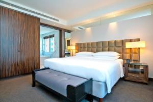 迪拜voco - Bonnington Dubai, an IHG Hotel的卧室配有白色大床和长凳
