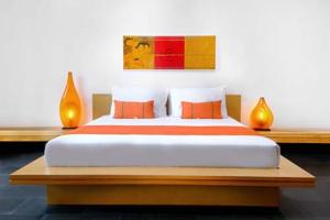 塞米亚克Bali Island Villas & Spa CHSE Certified的一间卧室配有一张带橙色枕头的大床