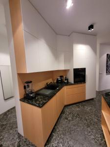 霍夫克莱塔赛尔别墅的厨房配有白色橱柜和黑色台面