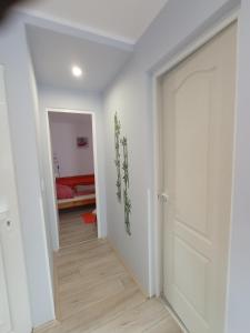 欧尔菲Fagoda-Fogadó Vendégház的一条带白色门的走廊和一间卧室