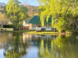 海姆维尔Mkomazana Mountain Cottages的湖畔的绿色屋顶房屋