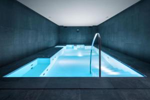 那不勒斯LHP Napoli Palace & SPA的大型游泳池设有大型蓝色浴缸
