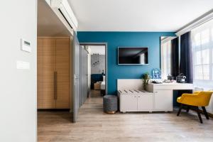 布达佩斯Alta Moda Fashion Hotel的一间设有蓝色墙壁和白色书桌的客房