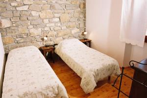 DekaniBordon wines, estate with accommodation的石墙客房的两张床